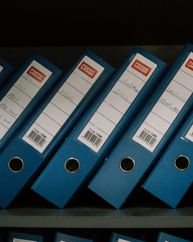Rows of company record binders on a shelf