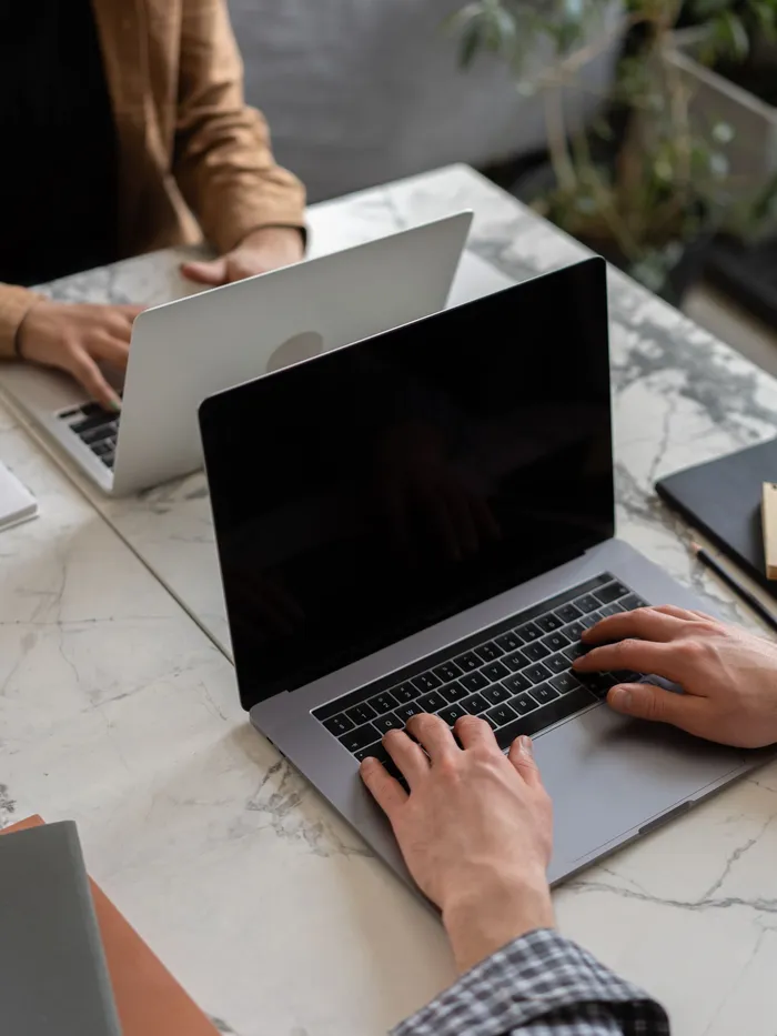 Two people reading on a laptop in a cafe