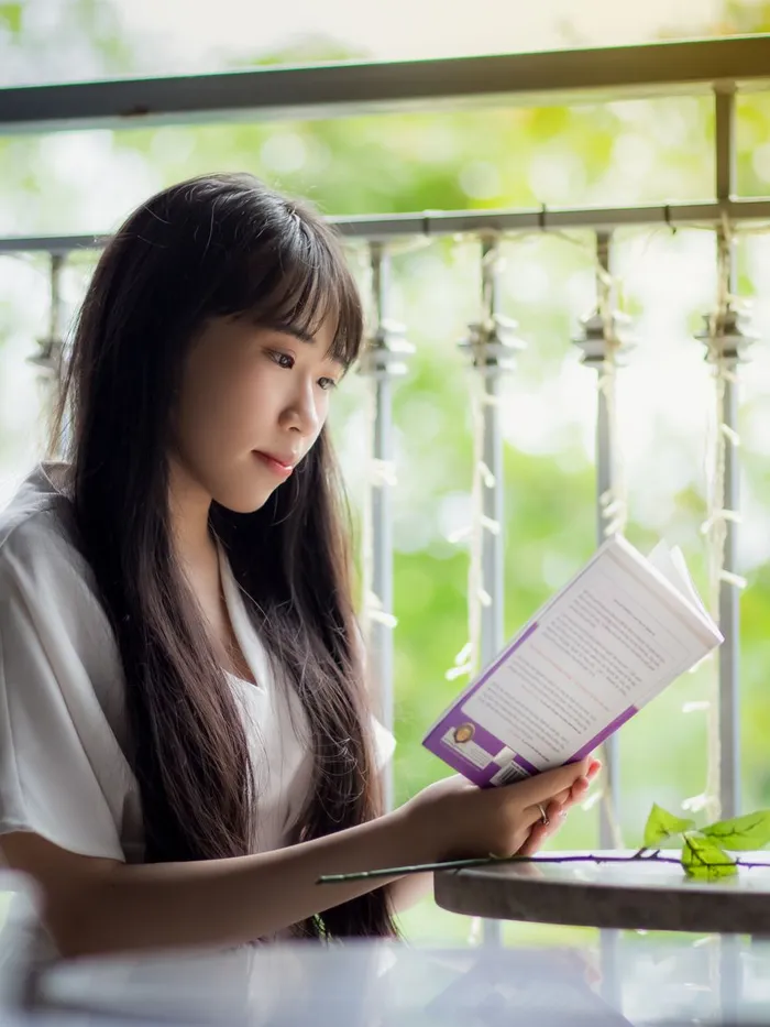A woman reading a guide at a cafe table